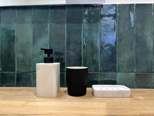 une brosse à dents et un distributeur de savon sur un comptoir dans l'établissement LE TREFLE DE FALGUIERE - Hypercentre- Gare, à Toulouse