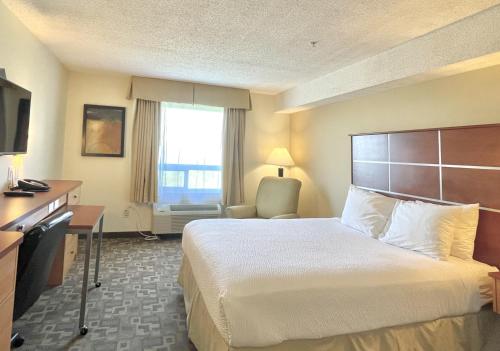 グランド・プレーリーにあるDays Inn by Wyndham Grande Prairieのベッド、デスク、テレビが備わるホテルルームです。