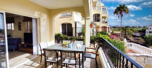 a patio with a table and chairs on a balcony at Casa Palmu apartment - A peaceful and relaxing oasis in Golf del Sur, Tenerife in San Miguel de Abona