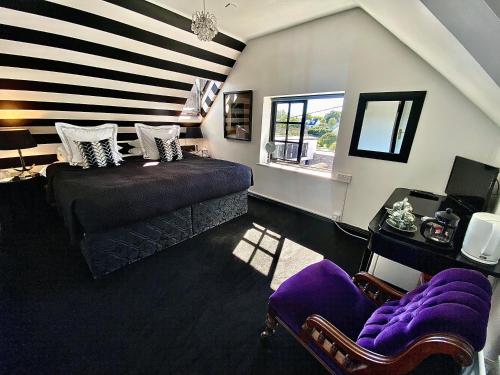 um quarto com uma cama roxa e uma janela em The K Kinsale em Kinsale