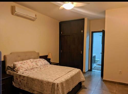 1 dormitorio con 1 cama y puerta a un balcón en Chácara Morada Do Sol, en Río de Janeiro