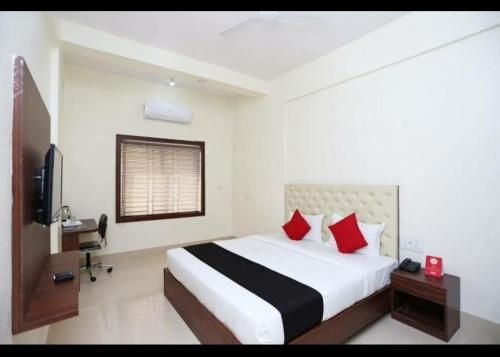 a bedroom with a large bed with red pillows at Triple Tree Hotel & Resorts in Bhubaneshwar