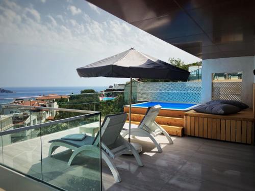 a patio with two chairs and an umbrella at Rhapsody Hotel & Spa Kalkan in Kalkan