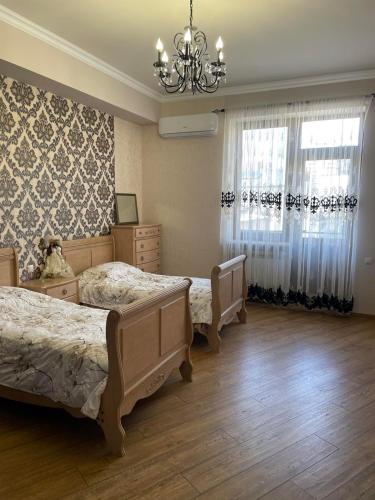 a bedroom with two beds and a chandelier at Nice villa in Yerevan