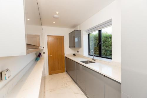 a kitchen with white counters and a wooden door at The Mayfair in Six Mile Bottom