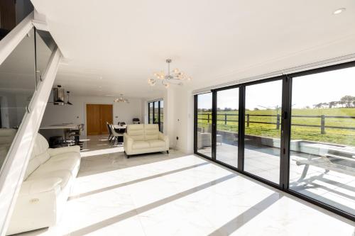 a living room with sliding glass doors and a dining room at The Mayfair in Six Mile Bottom