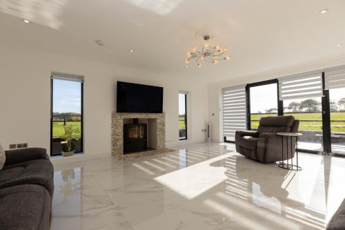 a living room with two chairs and a fireplace at The Mayfair in Six Mile Bottom