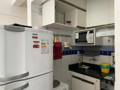 a kitchen with a refrigerator and a microwave at Apartamento Napoli in Salvador