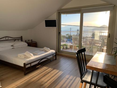 een slaapkamer met een bed en een balkon met uitzicht bij studio Palerostravel in Paleros