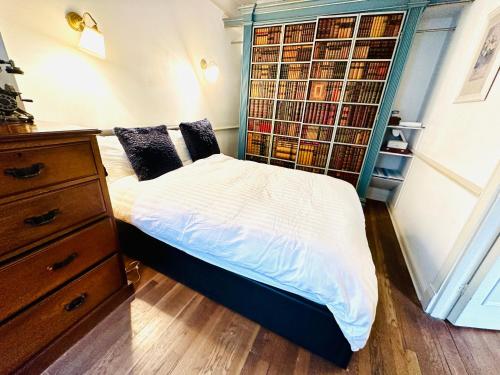 een slaapkamer met een bed en een boekenplank bij Perfect West End Launchpad in Londen