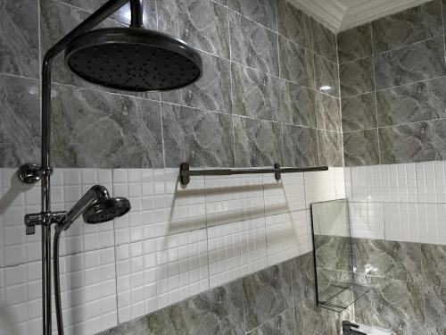 La salle de bains est pourvue d'une douche avec une porte en verre. dans l'établissement KAIR Service Apartments, à Benin City
