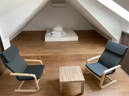 Spacious Apartment in Town Centre في نوفي زامكي: كرسيين وطاولة في العلية