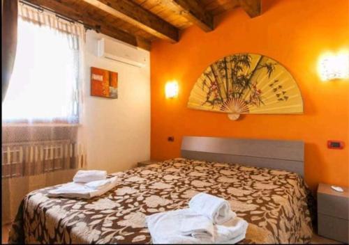 a bedroom with a bed with an orange wall at Villa Nuccia Oasi di relax con piscina in Castellammare del Golfo