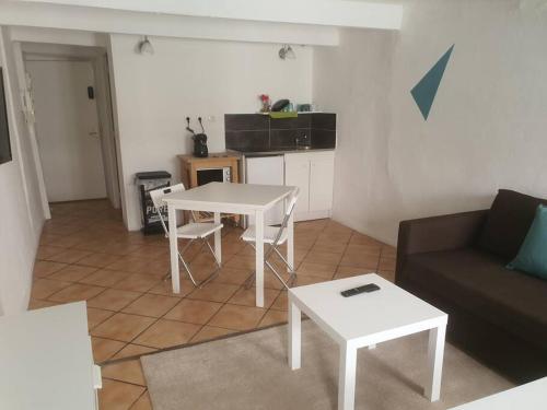 un salon avec une table blanche et un canapé dans l'établissement Budgetbnb 184, confortable studio proche opéra clim, à Toulon