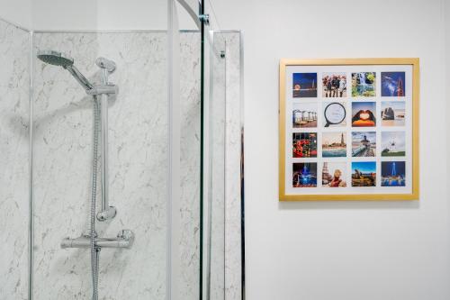 uma casa de banho com um chuveiro e uma imagem na parede em Private Yard, Free Parking & Games at Laburnum House em Blackpool