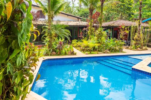 a swimming pool in front of a house at Vila dos Tupinambás in Boicucanga