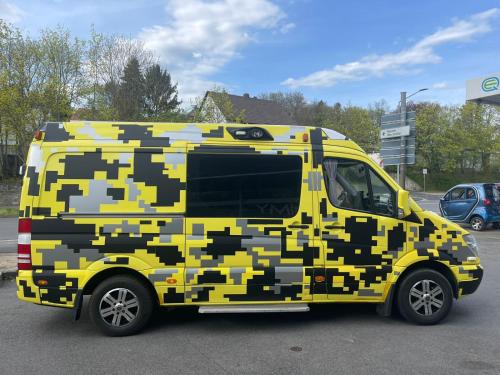 a yellow and black camo van parked in a parking lot at Дом на колесах (Караван) in Puerto de Sagunto