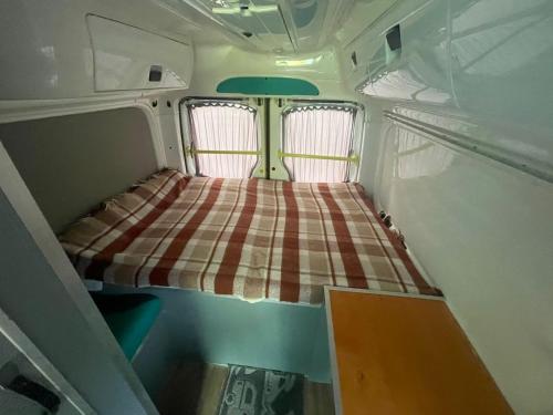 ein kleines Zimmer mit einem Bett auf der Rückseite eines Anhängers in der Unterkunft Дом на колесах (Караван) in Puerto de Sagunto