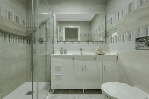 a white bathroom with a sink and a shower at SOL Y MAR in Torrevieja