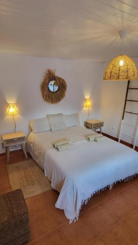 ヴィラ・ノヴァ・デ・ミルフォンテスにあるCantinho de Milfontes Jacuzziのベッドルーム1室(大型ベッド1台、ランプ2つ付)