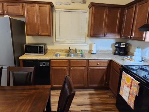 a kitchen with wooden cabinets and a sink at Spacious Villa close to the beach, 10 sleeps in Galveston
