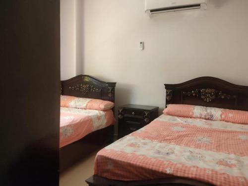 sypialnia z 2 łóżkami i 2 szafkami nocnymi w obiekcie شقة بكفر الشيخ w mieście Disūq