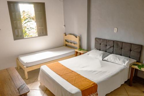 a bedroom with a bed and a bench in it at Vila dos Tupinambás in Boicucanga