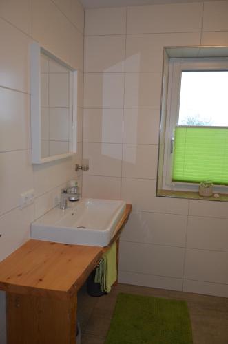 a bathroom with a sink and a green window at Fewo Maiberger in Schörfling