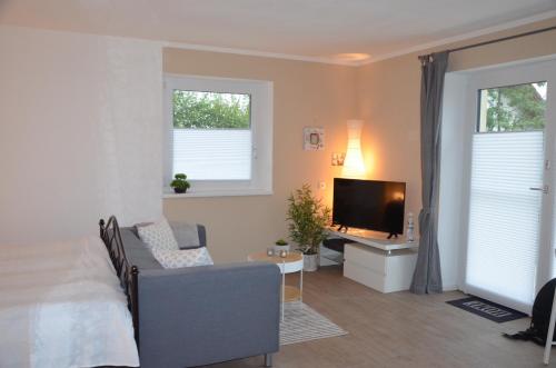 a bedroom with a bed and a tv and a couch at Fewo Maiberger in Schörfling