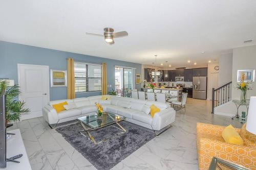 a living room with white couches and a kitchen at Luxury Villa inside Storey Lake, Kissimmee - No Extra Fees in Kissimmee