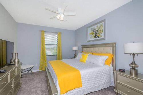 a bedroom with a bed and a ceiling fan at Luxury Villa inside Storey Lake, Kissimmee - No Extra Fees in Kissimmee