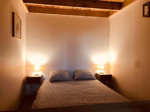 um quarto com duas lâmpadas em dois lados de uma cama em La Pomme d'Or em Bordeaux