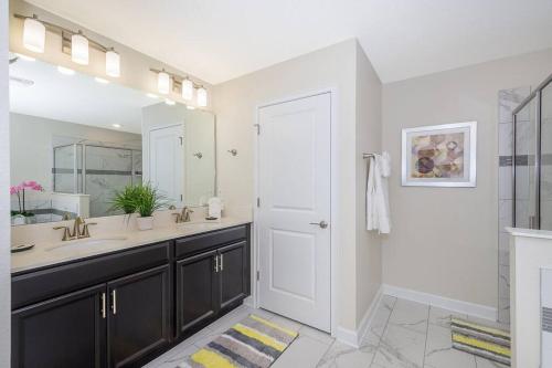 a bathroom with a sink and a large mirror at Luxury Villa inside Storey Lake, Kissimmee - No Extra Fees in Kissimmee