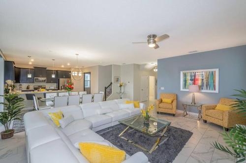 a living room with a white couch and a table at Luxury Villa inside Storey Lake, Kissimmee - No Extra Fees in Kissimmee