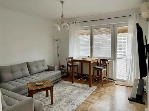 ein Wohnzimmer mit einem Sofa und einem Tisch in der Unterkunft Hyper Centre Apartment Prishtina in Pristina