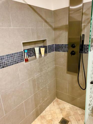 a bathroom with a shower with a glass door at Maison Cosyli in Meyzieu