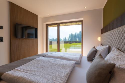 1 Schlafzimmer mit 2 Betten und einem großen Fenster in der Unterkunft Fankhauser Apartments in Ried im Zillertal