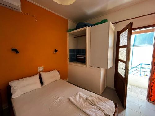 a small bedroom with a bed and a window at Selena Rooms in Agia Galini