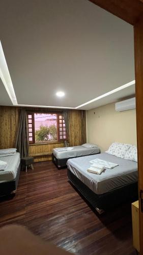 a room with three beds and a window at Apartamento Beira Mar Preá in Prea