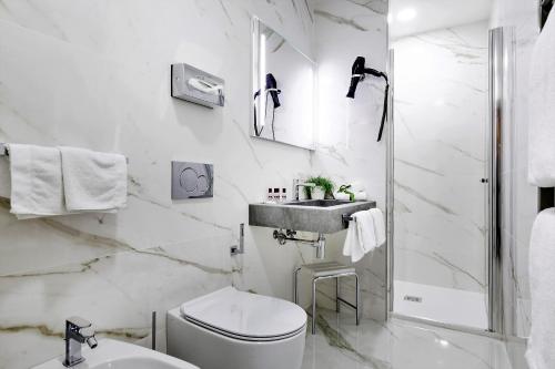 Baño blanco con aseo y lavamanos en Palazzo Schiavoni Residenza d'epoca & Suite-Apartments en Venecia