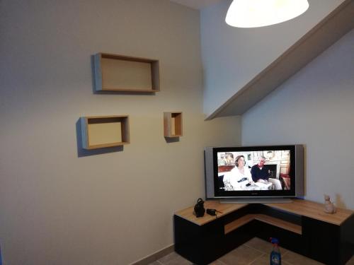 ein Wohnzimmer mit einem Flachbild-TV an der Wand in der Unterkunft Gîte du capitaine in Maranville