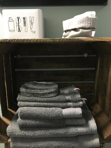 a pile of towels on a shelf in a bathroom at Suite Factory : gîte de charme en Avesnois in Wargnies-le-Petit