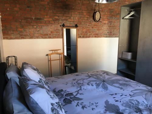 sypialnia z łóżkiem i ceglaną ścianą w obiekcie Suite Factory : gîte de charme en Avesnois w mieście Wargnies-le-Petit