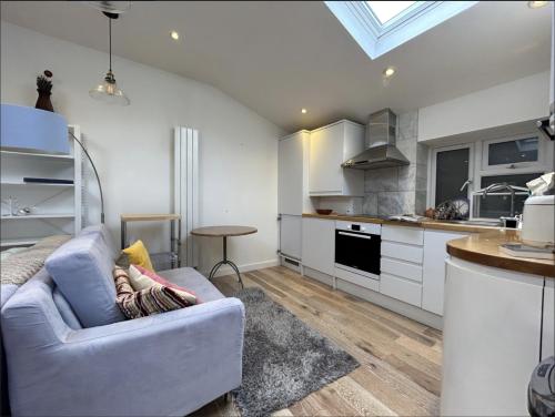 a living room with a couch and a kitchen at Mark Road Villa in Oxford