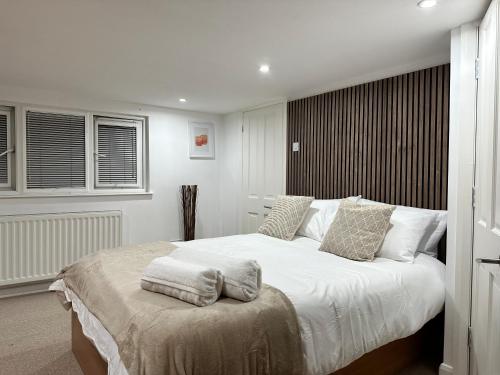 - une chambre avec un grand lit blanc et des oreillers dans l'établissement Mark Road Villa, à Oxford