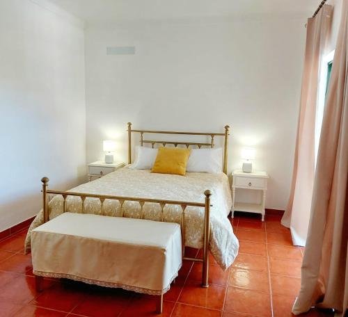 a bedroom with a bed with a yellow pillow on it at Casa das Laranjeiras in Vale de Figueira