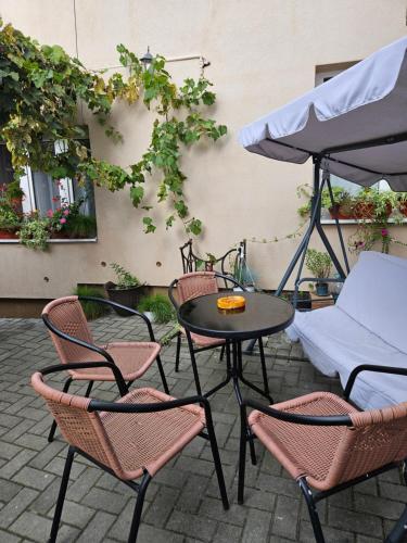 a patio with a table and chairs and an umbrella at Vintage Apartment - Ultracentral, 2 dormitoare in Sighişoara