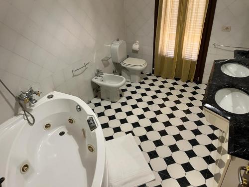 a bathroom with a tub and a toilet and a sink at Il Cielo di Lucio in Pisa