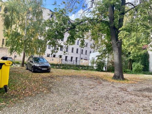 un coche aparcado en un estacionamiento junto a un árbol en Beautiful, spacious apartment! Free Private Parking, en Riga