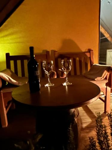 a table with a bottle of wine and glasses on it at GLAMPING SUITE IL GRILLO in Lamporecchio